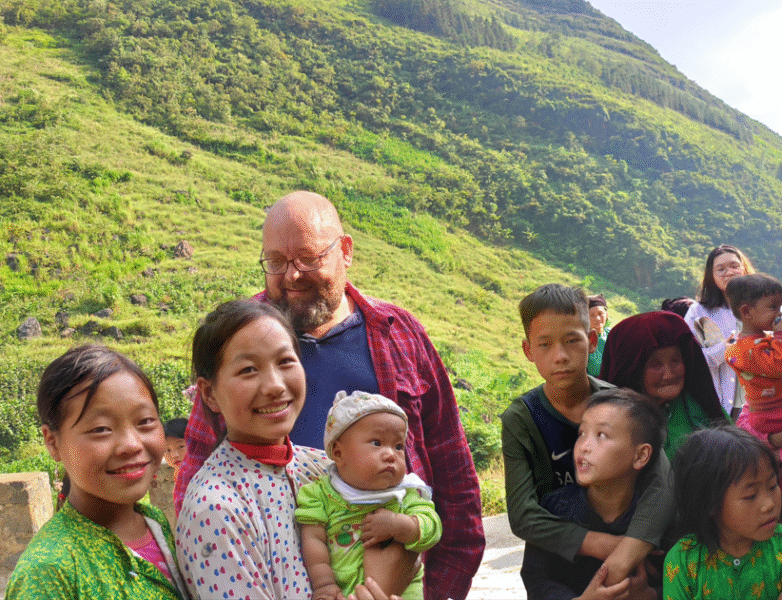Thomas med lokale der sælger blomster ved et bjergpas i Ha Giang provinsen.